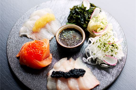 Sashimi tasting -annoksessa on sashimilajitelma, mätiä, wasabisoija-dressing, wakamea ja tuoretta wasabia.