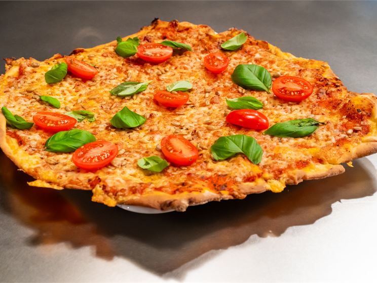 Miska Haakanan mozzarella-cheddarpizza, paahdettuja auringonkukansiemeniä, kirsikkatomaattia ja basilikaa